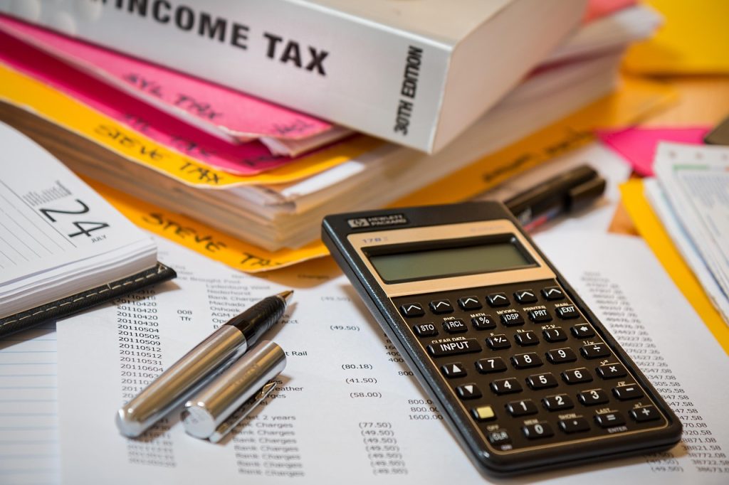 Income tax book, calculator and tax papers on a desk