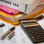 Income tax book, calculator and tax papers on a desk